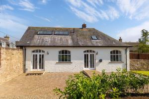a white house with a roof with windows at The Coach House in Alyth