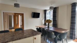 a kitchen and dining room with a table and chairs at The Coach House in Alyth