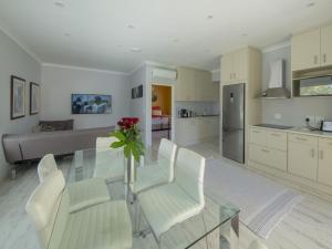 a dining room with a glass table and white chairs at Junior-Suite Merlot in Cape Town