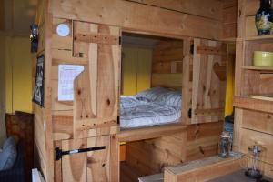 a wooden cabin with a bed inside of it at Puy Rond Camping in Bressuire