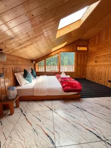 a bedroom with a bed in a wooden cabin at Venky's Shoja in Jibhi +21 photos