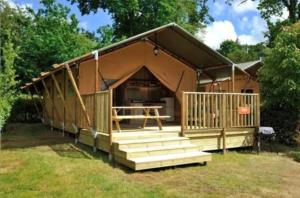 a house with a porch and stairs in a yard at Puy Rond Camping in Bressuire