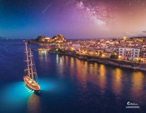 a boat in the water with a city at night at Corfu Villa Poulos in Astrakeri