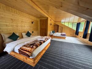 a bedroom with a large bed in a wooden cabin at Venky's Shoja in Jibhi