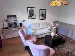 a living room with a couch and two chairs at Centrumnära in Gothenburg