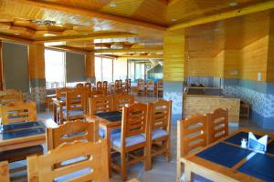 a dining room with wooden tables and chairs at The Park Green Resorts in Manāli