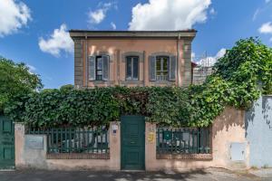 a house with green doors and ivy on it at Ponte Milvio Roma Elegance Room & Private Parking in Rome