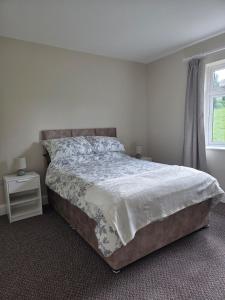 a bedroom with a large bed and a window at Meadow View in Kilkenny