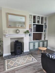 a living room with a fireplace and a mirror at Meadow View in Kilkenny