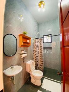a bathroom with a toilet and a sink at Secluded, Modern, Minimalist house - Gray House in Dampalan