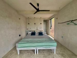 a bedroom with a bed and a ceiling fan at Casa Lai in Mazunte
