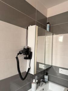 a bathroom mirror with a phone on the wall at Appartement de luxe Al hoceima in Al Hoceïma +12 photos