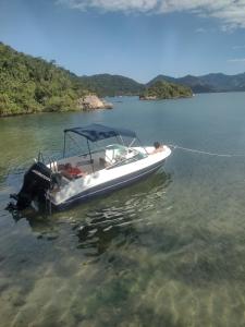 a man on a boat in the water at Lancha melodia paraty in Paraty