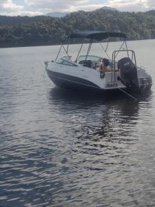 a white boat floating on a body of water at Lancha melodia paraty in Paraty