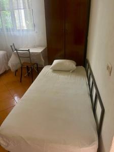 a bedroom with a bed and a table and a chair at Mani rooms in Durrës +2 photos