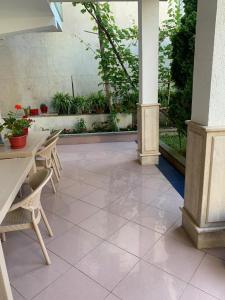 an outdoor patio with tables and chairs and plants at Mani rooms in Durrës