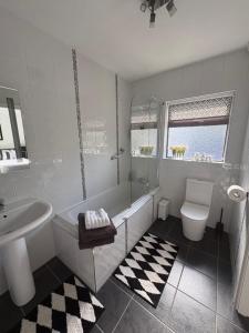 a bathroom with a tub and a sink and a toilet at Robin Hill Bed and Breakfast in Curracloe