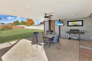 a patio with a table and chairs and a grill at Kidston Arches - HotTub - 2 Min Walk to Golf Course in Mansfield