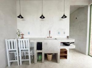 a kitchen with a sink and two white chairs at Casa Lai in Mazunte +29 photos