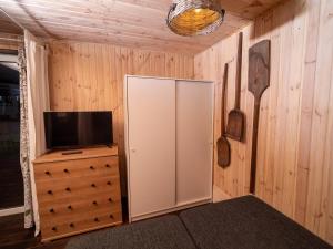 a room with a tv and a cabinet with a television at Leśna Chata in Bierzów