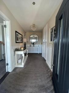 a hallway with a mirror and a white table at Robin Hill Bed and Breakfast in Curracloe