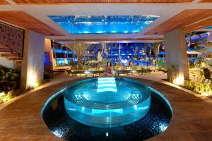 a woman sitting in a pool in a hotel lobby at Arte da Natureza Hotel Bonito in Bonito