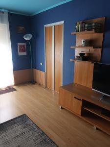 a living room with a tv and a blue wall at 2 precu 17 in Daugavpils +5 photos