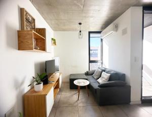 a living room with a couch and a table at Departamento 1 dormitorio Edificio SnJ in Rosario