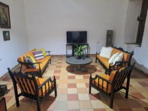 a living room with couches and a table and a tv at Hospedaje Don Juan in Barichara