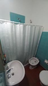 a bathroom with a white sink and a toilet at Hostería Amancay in Merlo +16 photos