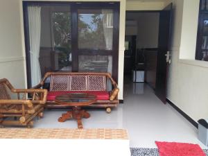 a room with a glass table and chairs on a porch at Puri Mandhara Lovina in Lovina