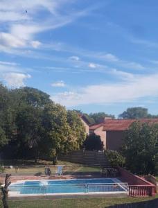 a swimming pool with a chair next to a house at Hostería Amancay in Merlo