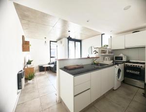 a kitchen with white cabinets and black counter tops at Departamento 1 dormitorio Edificio SnJ in Rosario