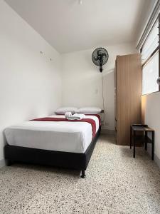 a bedroom with a bed and a lamp and a window at Roomies House By Rincon in Medellín