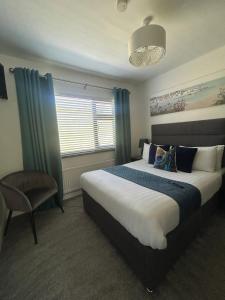 a bedroom with a large bed and a chair at Robin Hill Bed and Breakfast in Curracloe +17 photos