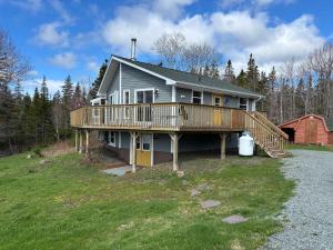 a large house with a deck and a barn at Sunrise Place Bed & Breakfast in DʼEscousse