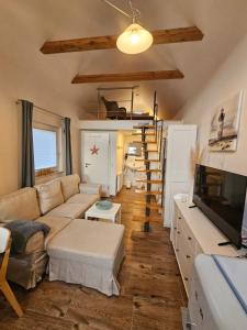 a living room with a couch and a tv at Ferienhaus Seeschwalbe in Tossens
