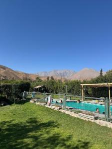 a large swimming pool with mountains in the background at Rancho Elquino in Vicuña