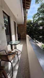a patio with a glass table and a chair at Roomies House By Rincon in Medellín