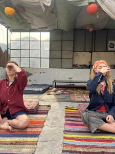 two girls sitting on the floor in a room at Tiny Spot Hostel Rishikesh in Rishīkesh