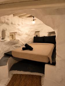 a bed in a stone walled room with a bed in it at Artemis Cottage Authentic Mykonian Stone House near Super Paradise in Super Paradise Beach