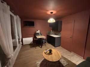a small room with a table and a kitchen at Le Studio de Paulette in Cucq