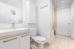 a white bathroom with a toilet and a sink at Downtown Toronto CN tower Condo in Toronto +45 photos