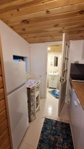 a kitchen with a white refrigerator and a table at Дом у моря in Suurupi +10 photos