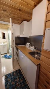 a kitchen with white cabinets and a sink at Дом у моря in Suurupi