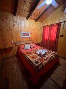 a bedroom with a bed in a wooden room at Cabañas Grazie in Oliveros