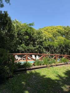 a pool with chairs in a yard with trees at Cabañas Grazie in Oliveros