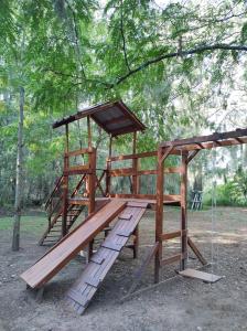 a wooden playground with a bench and a canopy at Cabañas Grazie in Oliveros +2 photos