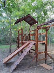 a wooden playground with a swing at Cabañas Grazie in Oliveros