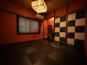 an empty room with a checkered floor and a window at 将軍町家 in Nagoya